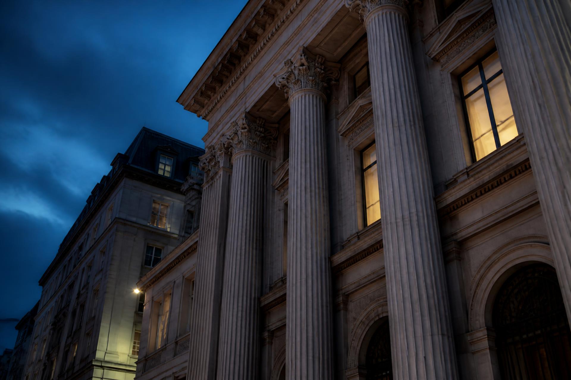 Classical stone facade of a European financial institution at dusk